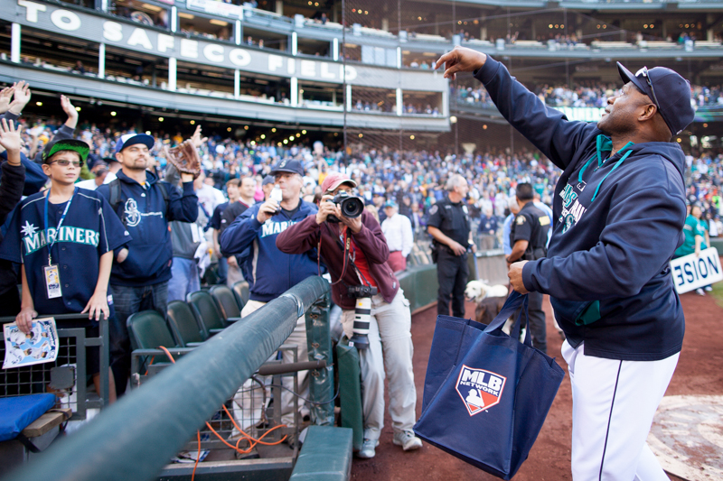Mariners' manager Lloyd McClendon tosses baseballs into the crowd after the game.