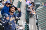 A father carries his boy to his seat as fans prepare for the Mariners' 162nd game.