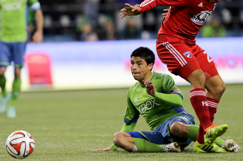 Midfielder Gonzalo Pineda takes a fall after battling for control with a Dallas defender in the first half.