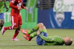 Seattle midfielder Osvaldo Alonso grimaces in pain, holding his hamstring. He left the game.