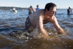 Bracing for an icy impact, a man takes a dive into the waters.