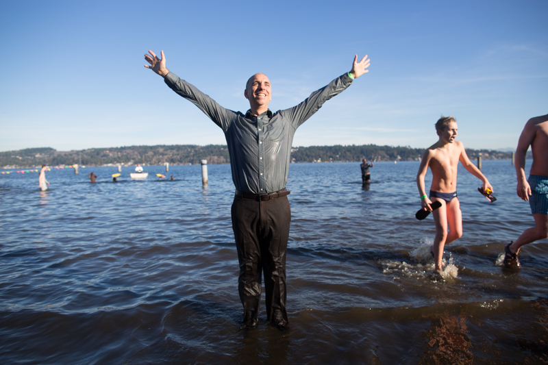 Fully dressed in business casual, a man celebrates his successful dip.