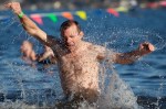 Thrashing about, a man ressurects himself from the water after taking a dunk.