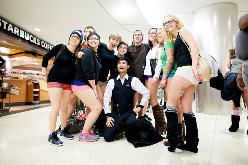 An airline employee poses with a group of riders.