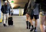 A passerby at SeaTac airport takes notice of the pant-less crowd walking by.