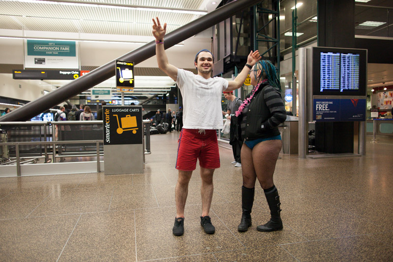 A passbery poses with a rider at SeaTac airport.