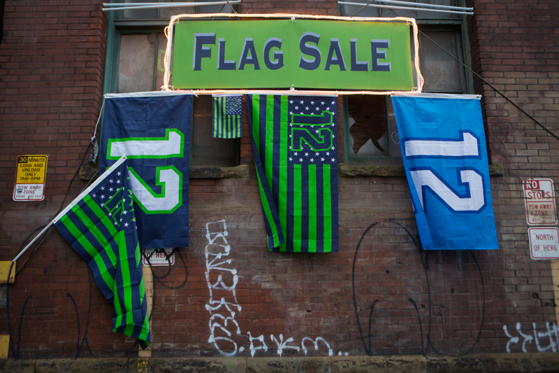 An assortment of flags hang ready to purchased outside the stadium.