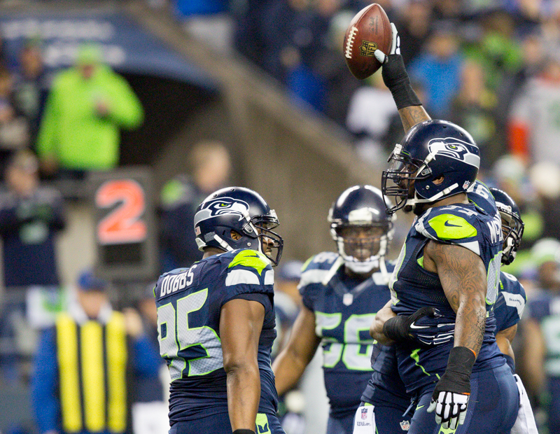 Seahawks' defensive tackle Tony McDaniel holds up his recovered fumble in celebration after the play in the first quarter.