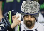 Wearing a giant SuperBowl ring hat, a fan attracts attention for selfies with other members of 12th man nation.