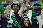 Seattle fans crowd the frame as a lone Carolina fan smiles weakly in the background.