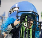 Dressed in a giant Hawks helmet, a fan cheers on the team in the fourth quarter.