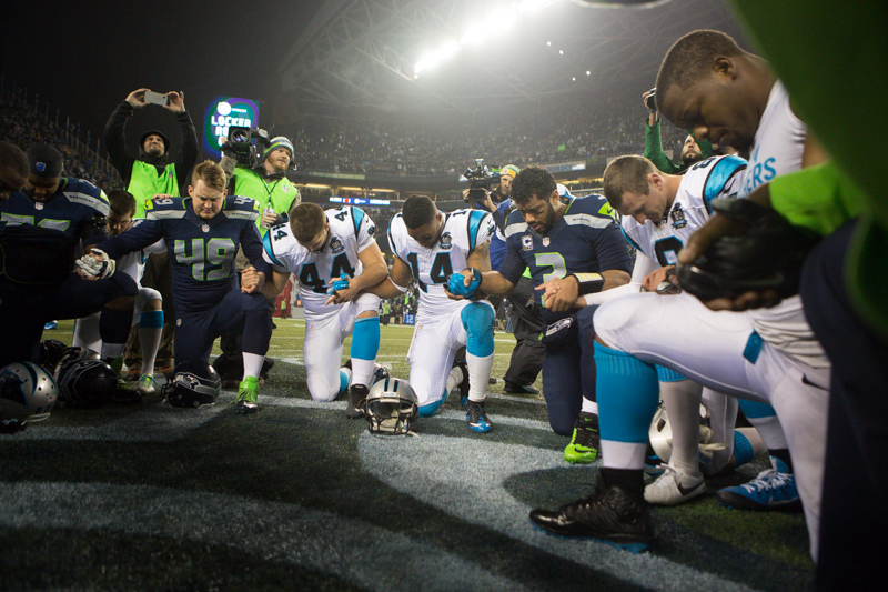 Players from both teams participate in the post-game prayer circle on the field after the game.