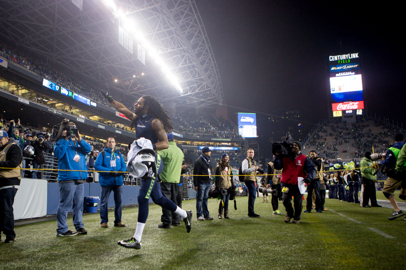 Richard Sherman waves to the crowd as he exits the field after his win.