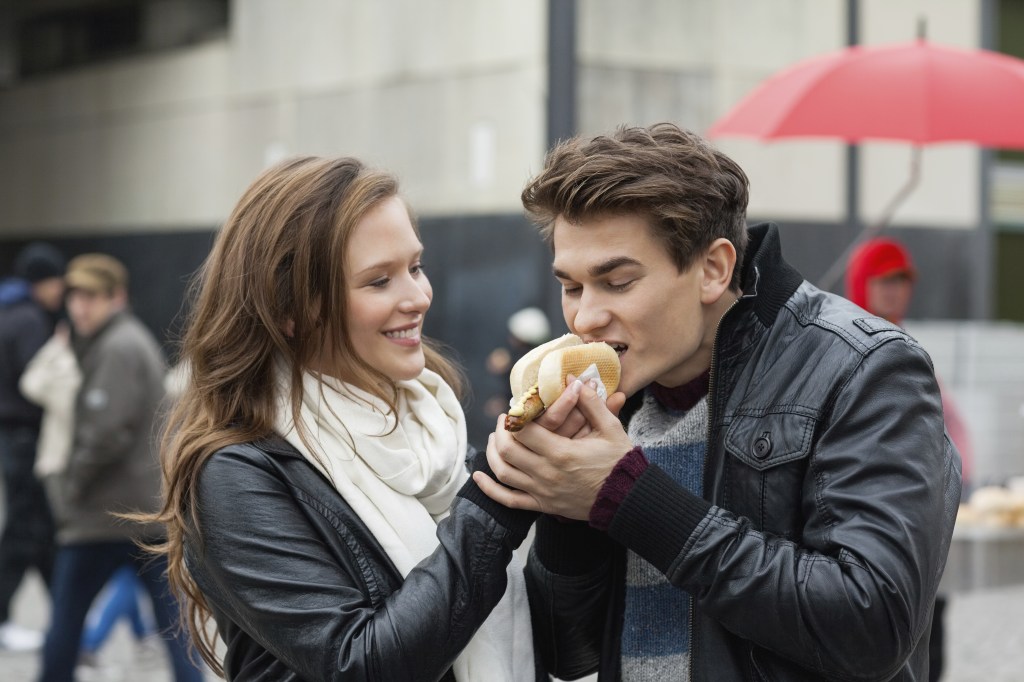 Woman Feeding Hotdog To Man