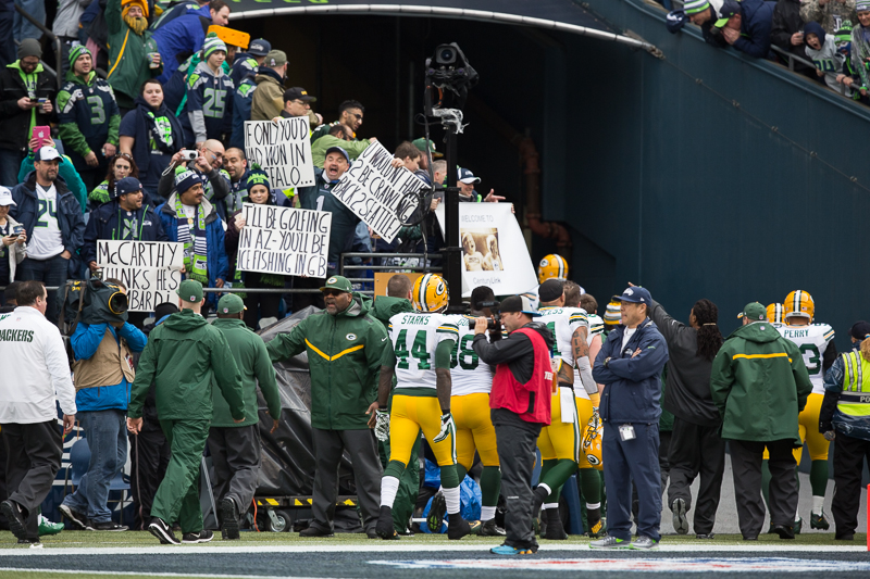 Packers players navigate their way through a sea of hostile Seahawks fans as they head back to the locker room before the game.