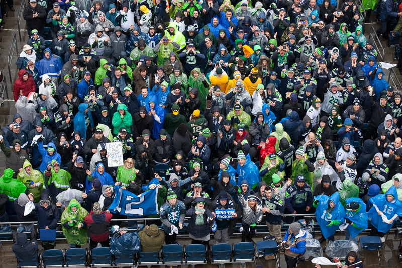 Hawk's fans turn to watch the 12th Man flag raised over the stadium before the game.