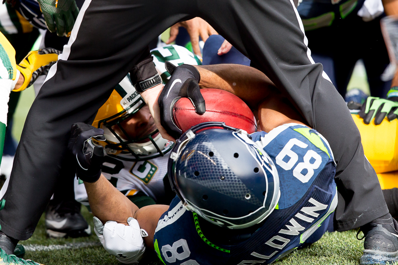 Hawks' receiver Doug Baldwin fights for the ball after a first-quarter fumble on a kick return. Green Bay recovered.