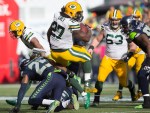 Green Bay running back Eddie Lacy rolls over the back of the Hawks' Richard Sherman in the first quarter for a gain of 9 yards.