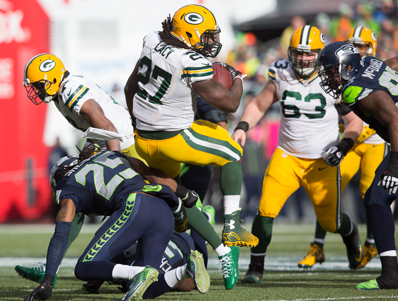 Green Bay running back Eddie Lacy rolls over the back of the Hawks' Richard Sherman in the first quarter for a gain of 9 yards.