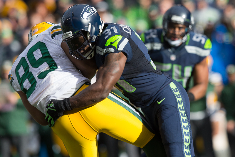 Hawks' safety Kam Chancellor knocks a Green Bay receiver off his feet in the first quarter.