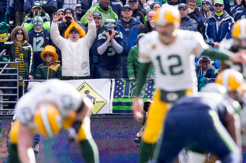 Alone in a sea of blue, Green Bay fans replete with cheese heads cheer a then-winning team in the second quarter.