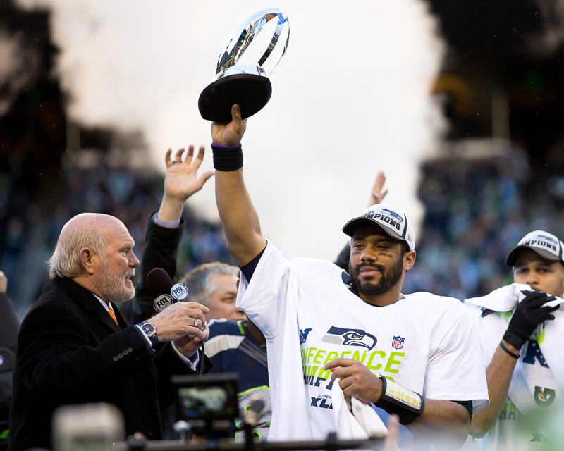  Russell Wilson holds up the NFC Championship trophy for all the 12s