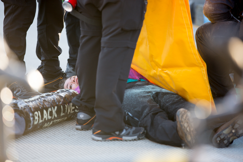 Police prepare a protester for extrication.