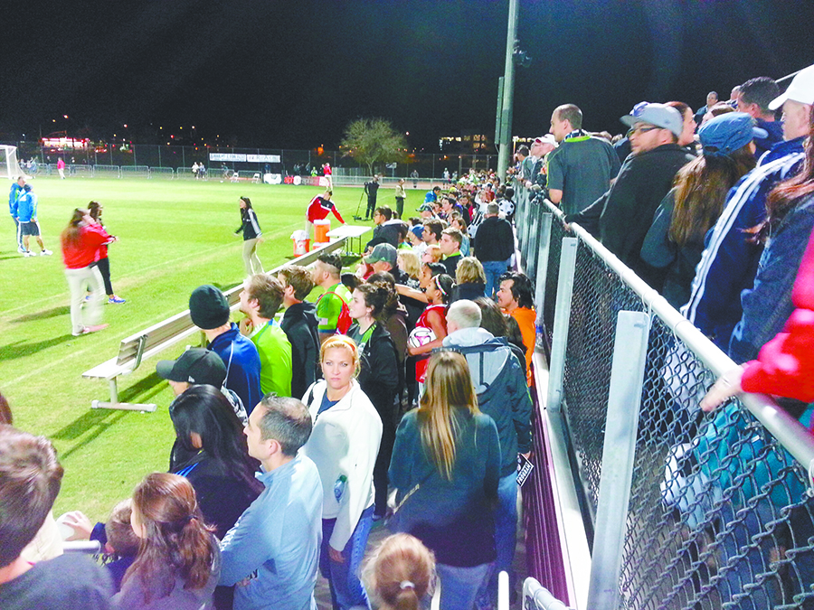 Left: Eager Sounders fans cluster behind the team’s bench. Right: pre-game stretches.