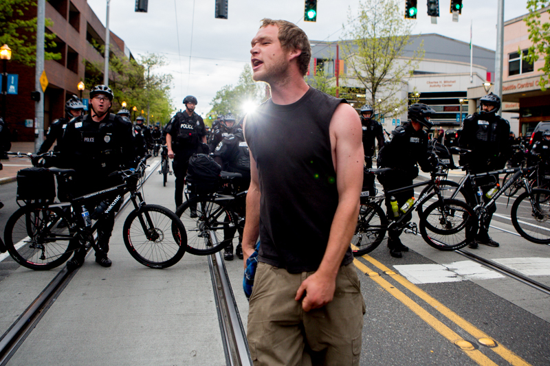 A man confronts police as they force the crowd south down Broadway.