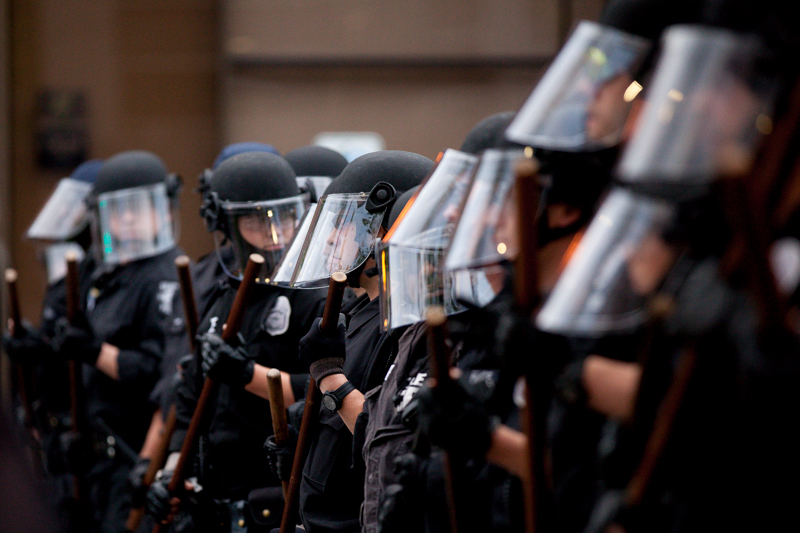 Seattle police in full riot gear form a line on Broadway.