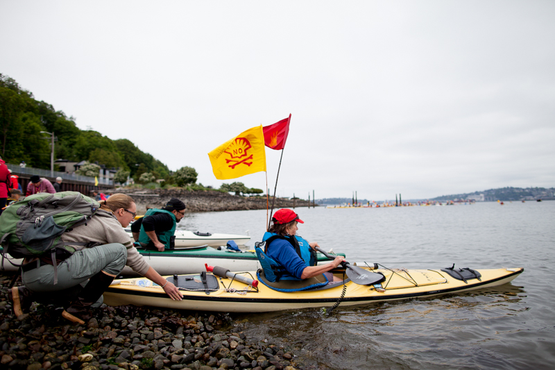 A kayaktivist gets a push as she heads out into the water.