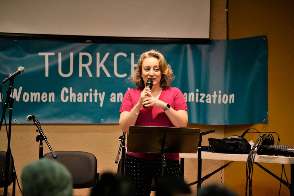 Tulin Yildiz speaks on the origin and significance of ashure in Turkish culture 
at Turkchas event at the Peter Kirk Community Center in Kirkland.                                 Photo courtesy of Dilek Anderson