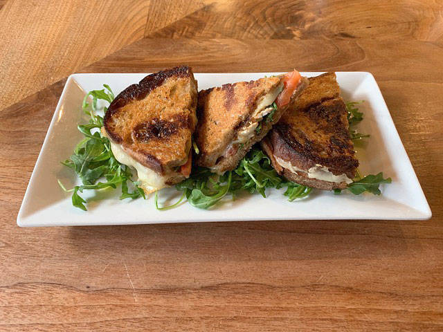 The PJ&B Grilled Cheese at The Gerald includes pancetta jam, brie, Swiss, caramelized onions, arugula, tomato, and balsamic reduction. Photo by Devynne Gannon