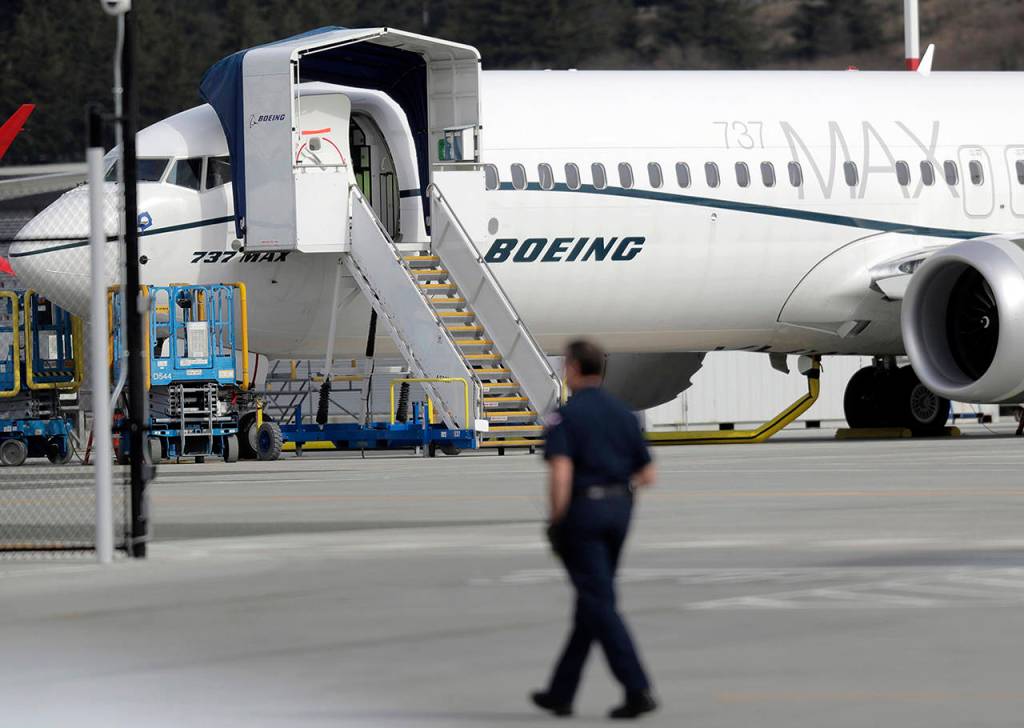 Ted S. Warren / associated press                                A worker walks next to a Boeing 737 MAX 8 airplane parked at Boeing Field in Seattle on Thursday.