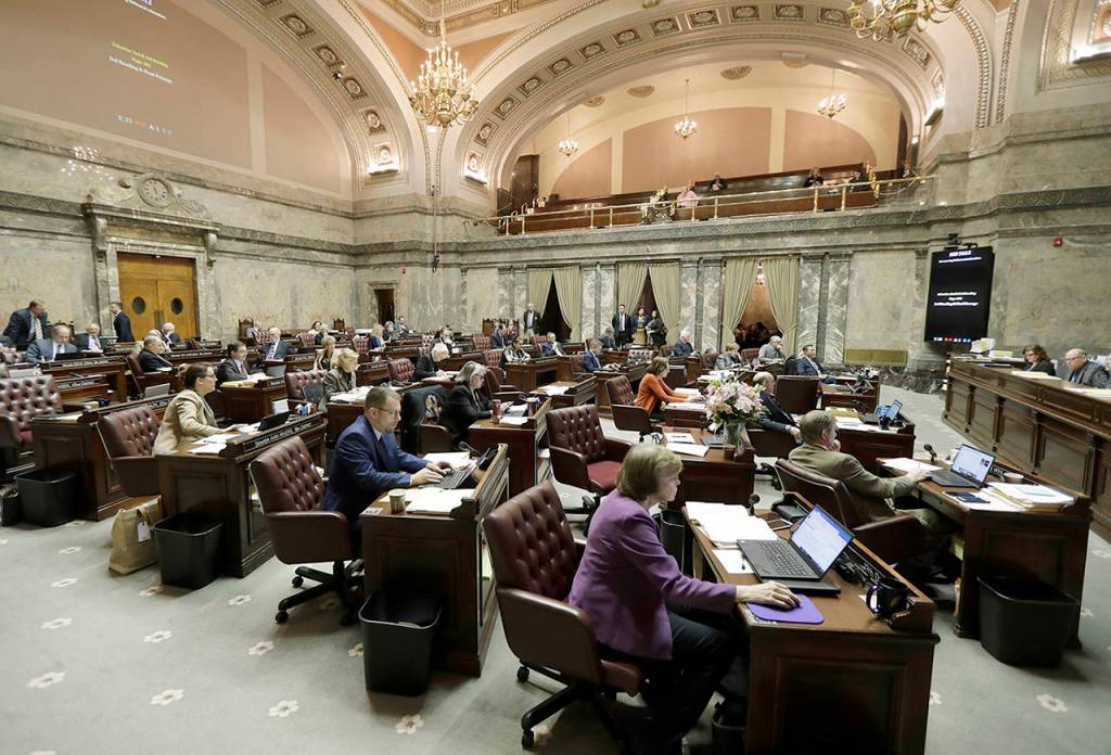 In this March 12 photo, Washington state Senators work on the Senate floor at the Capitol in Olympia. (AP Photo/Ted S. Warren)