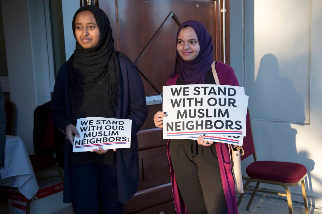 Ranya Ibrahim and Gowiria Yousif hand out signs outside the Muslim Association of Puget Sound mosque in Redmond. Ashley Hiruko/staff photo