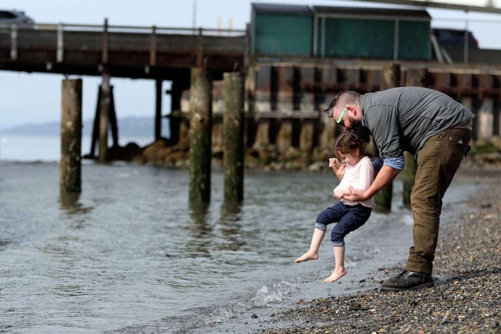 Matt Ober plays with his daughter Hazara Ober on Sunday afternoon at Olympic Beach in Edmonds. (Kevin Clark / The Herald)