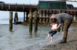 Matt Ober plays with his daughter Hazara Ober on Sunday afternoon at Olympic Beach in Edmonds. (Kevin Clark / The Herald)