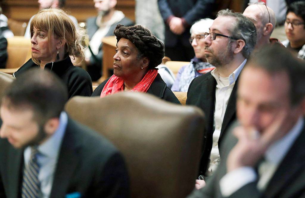 Washington state presidential electors Esther John (center) and Bret Chiafalo (right) sit behind their attorneys during a Jan. 22 Washington Supreme Court hearing in Olympia on a lawsuit addressing the constitutional freedom of electors to vote for any candidate for president, not just the nominee of their party. (Ted S. Warren / Associated Press, file)