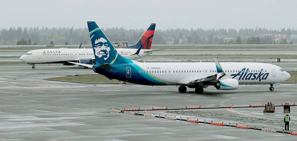 A Delta Air Lines Boeing 737 taxis behind a Alaska Airlines 737 at Seattle-Tacoma International Airport. (AP Photo/Ted S. Warren)