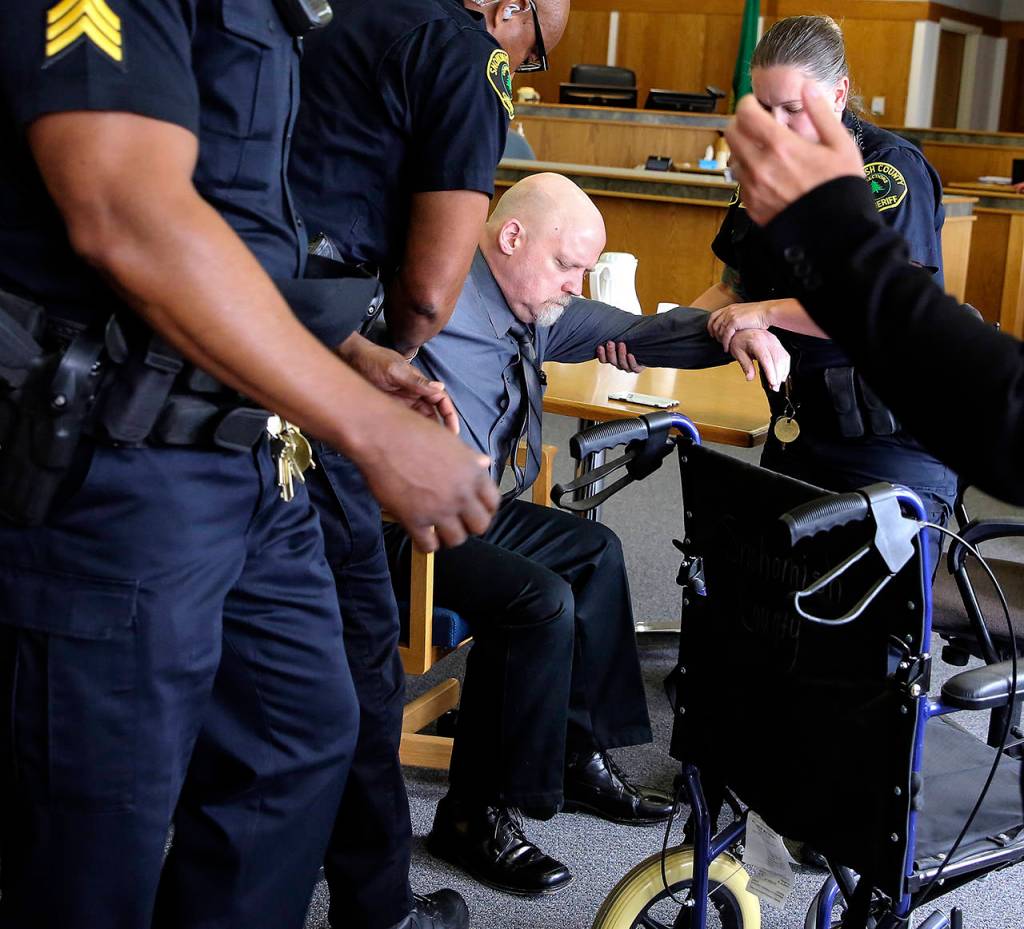 William Talbott II is helped to a wheelchair by Snohomish County Sheriffs Deputies after being found guilty on June 28 in the 1987 killings of Tanya Van Cuylenborg and Jay Cook. Jurors deliberated for more than two days before reaching their verdict in the trial that hinged on 32-year-old DNA evidence and genealogical technology. (Kevin Clark/The Herald via AP, Pool file)