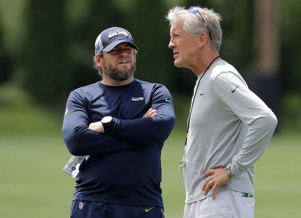Seahawks head coach Pete Carroll (right) talks with general manager John Schneider following an organized team activity on June 6, 2019, in Renton. (AP Photo/Ted S. Warren)