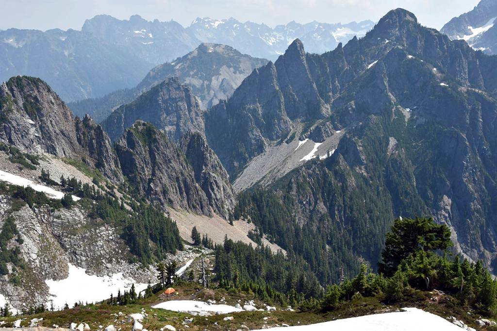 The view of east from Vesper Peak shows a climbers camp and Headlee Pass, at center, as well as the rugged terrain of the Glacier Peak Wilderness. (Caleb Hutton / The Herald)