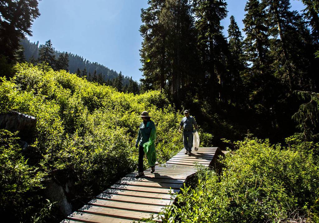 Jeri and Barry Elslip walk along the boardwalks looking for trash. (Olivia Vanni / The Herald)