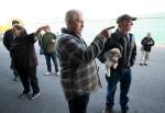 John Norman (center) explains which way pilot Ron Fowler, holding his dog, will take Normans replica of the Spirit of St. Louis out for its first flight at Arlington Municipal Airport on July 28. Heather Norman (left) explains the same to a friend. (Andy Bronson / The Herald)