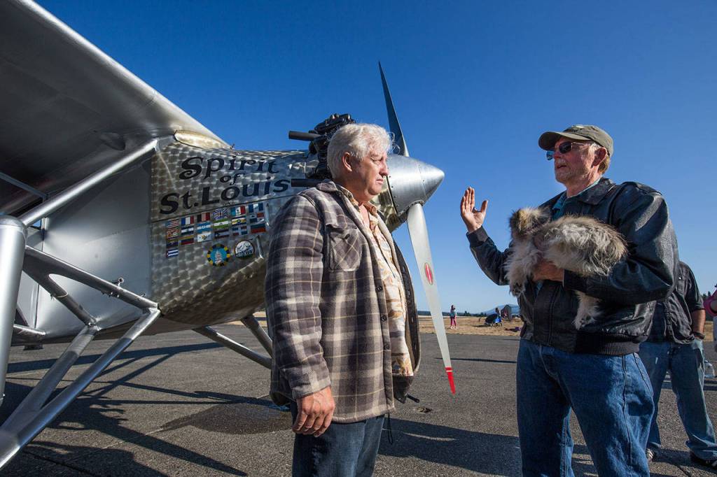 John Norman listens as pilot Ron Fowler explains what happened during the first flight of Normans replica of the Spirit of St. Louis from Arlington Municipal Airport on July 28. (Andy Bronson / The Herald)
