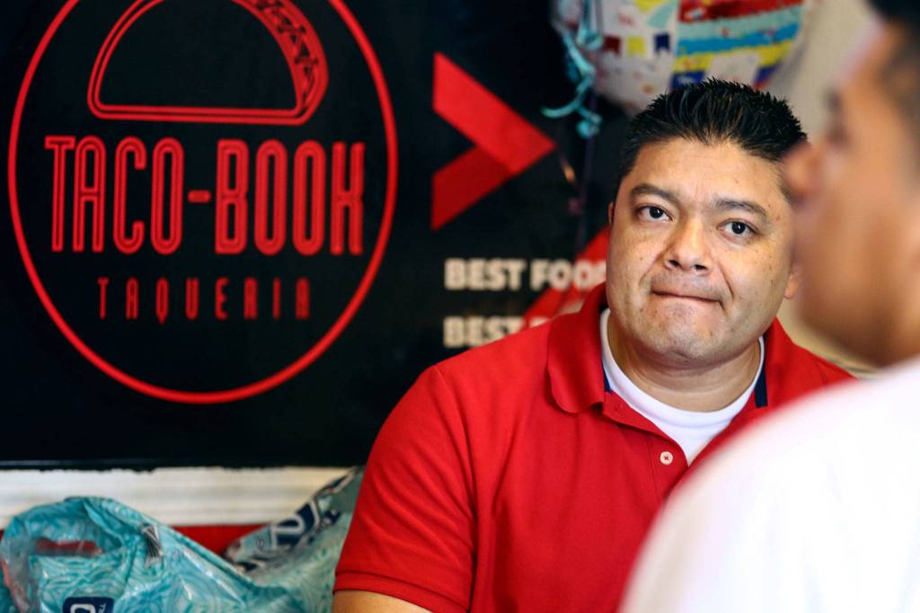 Rigoberto Bastida waits on a customer at Taco-Book in Everett. (Kevin Clark / The Herald)