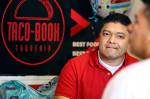 Rigoberto Bastida waits on a customer at Taco-Book in Everett. (Kevin Clark / The Herald)