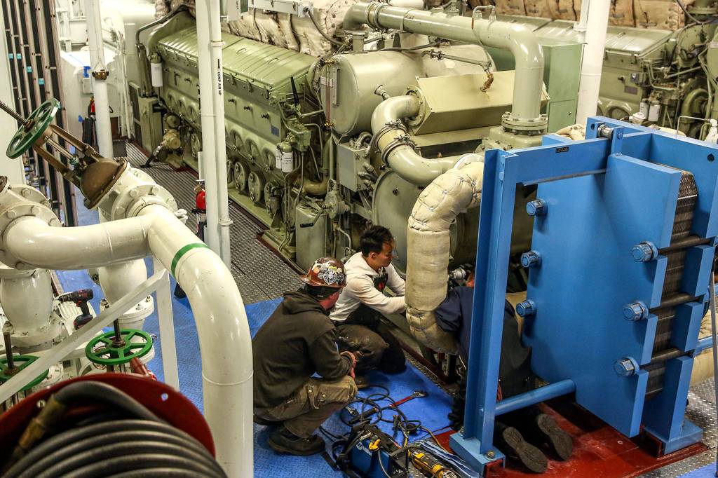 Crews work to replace and refit a water filter system aboard the Puyallup at the Eagle Harbor Maintenance Facility in Bainbridge on October 31, 2019. (Kevin Clark / The Herald)
