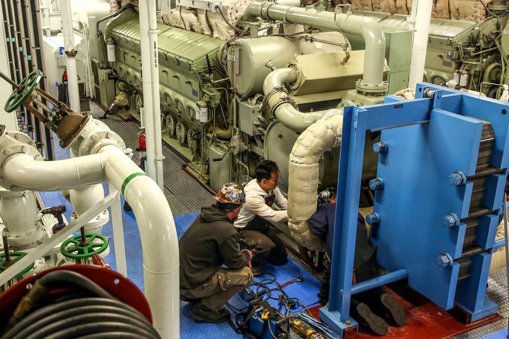 Crews work to replace and refit a water filter system aboard the Puyallup at the Eagle Harbor Maintenance Facility in Bainbridge on October 31, 2019. (Kevin Clark / The Herald)